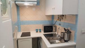 Una pequeña cocina con fregadero y microondas. en Olival Home- Feels like home, en Lisboa