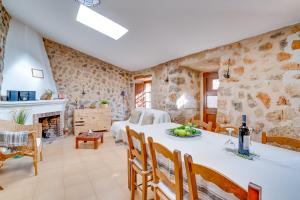 a large living room with a table and a fireplace at Casita de Montaña cerca del mar in Fornalutx