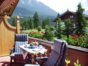 a table and two chairs on a balcony with a view at Ferienhaus Alpenzauber in Krün