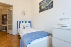 ウィーンにあるOperastreet City Center Santorinの小さなベッドルーム(ベッド1台付)が備わります。壁には絵画が飾られています。