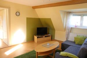 a living room with a couch and a tv at Ferienwohnung Lahann in Saalfeld