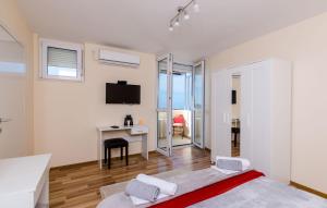 a bedroom with a bed and a desk with a monitor at Apartment Vedrana in Dubrovnik