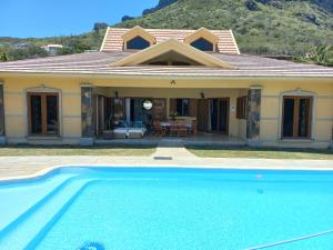 a house with a swimming pool in front of it at La Villa Marie Joana in Le Morne