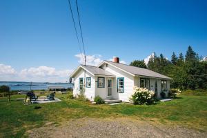 una piccola casa bianca con un tavolo da picnic di fronte di Friars Bay Inn & Cottages a Welshpool
