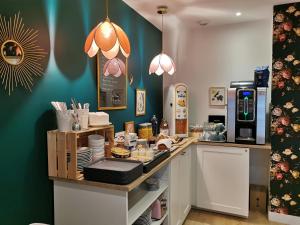 a kitchen with a counter with food on it at Hôtel La Fontaine Caen Centre in Caen