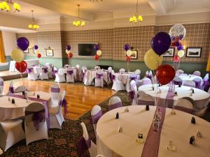 um salão de banquetes com mesas brancas e balões em The Bridge Inn Hotel em Bolton