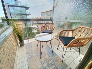uma varanda com 2 cadeiras e uma mesa na varanda em Casa Leon em Ostend