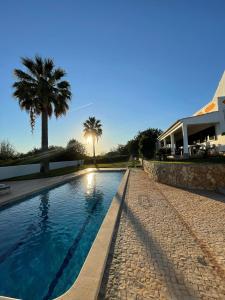 オリョンにあるCasa Esperança - carefree living with big private pool and great viewsのヤシの木と家のあるスイミングプール