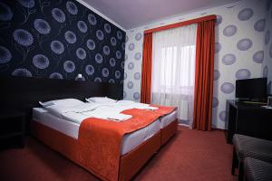 1 dormitorio con 1 cama con manta roja y ventana en Kars, en Kozel'sk