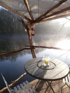 a table with a candle on top of a lake at Cabane de l'aventurier in Saint-Nabord