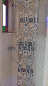 a bathroom with a shower with a tile wall at Cabane de l'aventurier in Saint-Nabord