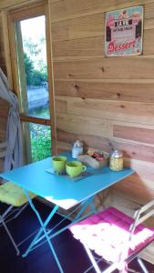 a blue table with two green bowls on it at Cabane de l'aventurier in Saint-Nabord