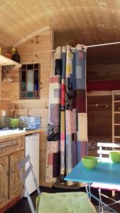 a kitchen with a table and a curtain in a kitchen at Cabane de l'aventurier in Saint-Nabord