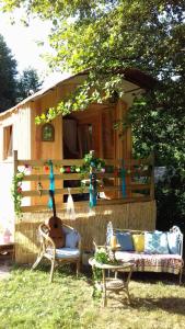 a cabin with a table and chairs and a guitar at Cabane de l'aventurier in Saint-Nabord