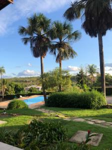 a resort with palm trees and a swimming pool at Pousada das Palmeiras in Posse