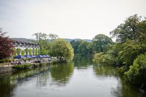 a river with a building next to a river at The Swan Hotel and Spa in Newby Bridge