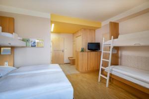 a bedroom with two bunk beds and a ladder at JUFA Hotel Bleiburg - Pliberk in Bleiburg
