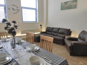 een woonkamer met een tafel en een bank bij City Centre duplex 3rooms apartment with parking in Nottingham