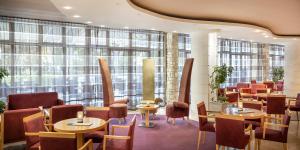 - un restaurant avec des tables, des chaises et de grandes fenêtres dans l'établissement Aminess Laguna Hotel, à Novigrad