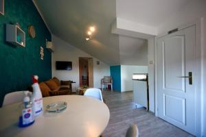 a room with a white table and a living room at Apartman Azra in Kikinda