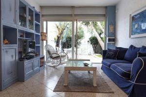 a living room with a blue couch and a table at Santa Marinella - La Terrazza sul Mare in Santa Marinella