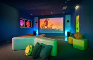 a living room with a lion king movie on the screen at JUFA Hotel Bleiburg - Pliberk in Bleiburg