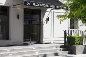
a white building with a blue door and a black and white sign at Allobroges Park Hôtel in Annecy
