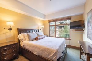 a bedroom with a bed and a flat screen tv at Ski In Ski Out Corner Unit Direct Views Slopes Gondola Conde Nast and Forbes Winner in Park City