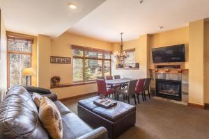 a living room with a couch and a table with a fireplace at Ski In Ski Out Corner Unit Direct Views Slopes Gondola Conde Nast and Forbes Winner in Park City