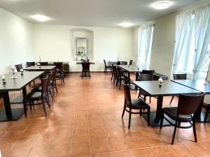 a dining room table with chairs and tables in it at Hotel Stará Pošta in Zdiby