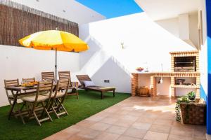 a dining room with a table and a yellow umbrella at Alma do Mar in Baleal