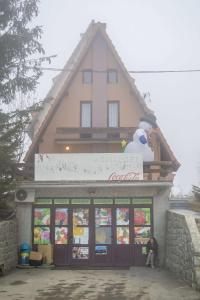 a person sitting in front of a store at Vila Milica in Kopaonik