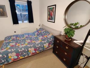 a bedroom with a bed and a dresser and a mirror at Award Winning Apartment in Yarm, North Yorkshire in Yarm