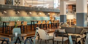 a restaurant with tables and chairs and a couch at Aminess Vival Maestral Hotel in Novigrad Istria