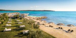 an aerial view of a beach with chairs and umbrellas at Aminess Vival Maestral Hotel in Novigrad Istria