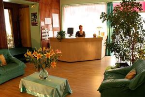 a lobby with two couches and a person at a counter at Hôtel des Pyrénées in Angoulême