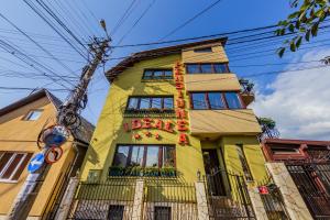 a yellow building with a sign on it at Pensiunea Ideal in Baia Mare