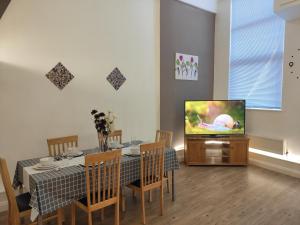 een woonkamer met een tafel en een televisie bij City Centre duplex 3rooms apartment with parking in Nottingham