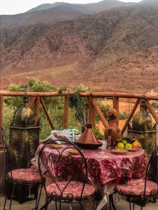 a table and chairs with a view of a mountain at Chez Imnir in Ijjoukak