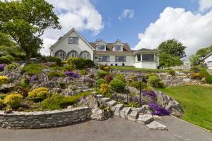 uma casa com uma parede de pedra e um jardim em Rockcrest House em Kenmare