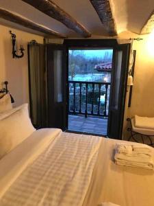 a bedroom with a bed and a view of a balcony at La Posada de Leza Your wine country getaway in Laguardia