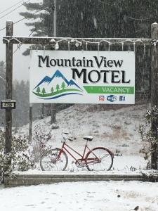 una bicicleta estacionada junto a un cartel de motel con vistas a la montaña en Mountain View Motel & Campground, en Stratton
