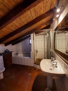 a bathroom with a sink and a toilet and a tub at Attico Los Montes with private pool in Viñuela