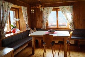 ein Esszimmer mit einem Tisch und 2 Fenstern in der Unterkunft Ferienhaus Wille in Maurach