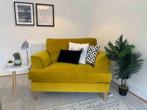 un sofá amarillo en una sala de estar con mesa en Stylish & Spacious 3 Bed House With 2 Free Car Parking Spaces, en Appledram