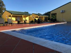 a swimming pool next to a building with chairs around it at Quinta Santa Rita - Príncipe in Cascalheira