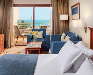 a hotel room with a bed and a living room at H10 Playa Meloneras Palace in Meloneras