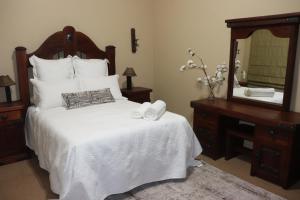1 dormitorio con 1 cama blanca grande y espejo en Kleine Kaap - Selfsorg en Orania