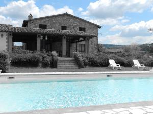 una casa con piscina di fronte a una casa di La Campagna Di Assignano a Collazzone