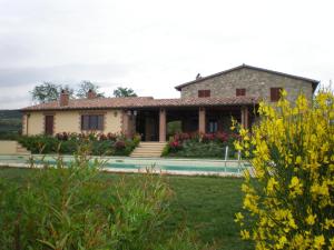 une maison avec une piscine en face d'une cour dans l'établissement La Campagna Di Assignano, à Collazzone